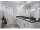 Bright bathroom featuring a double sink vanity with granite countertop and white cabinets at 10699 Petrillo Way, Winter Garden, FL 34787