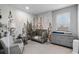 Bedroom showcasing a mountain mural, crib, comfortable chair, and a changing table at 10699 Petrillo Way, Winter Garden, FL 34787