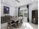 Dining room with modern chandelier, stylish furniture, a large window, and elegant accents at 10699 Petrillo Way, Winter Garden, FL 34787