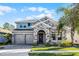 Charming two-story home with stone accents, gray exterior, and well-manicured front lawn at 10699 Petrillo Way, Winter Garden, FL 34787