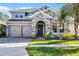 Beautiful two-story home with stone facade, three-car garage, and well-maintained landscaping at 10699 Petrillo Way, Winter Garden, FL 34787