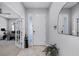 Inviting foyer with light wood floors, a front door with glass, and an elegant mirror at 10699 Petrillo Way, Winter Garden, FL 34787