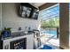 Outdoor kitchen complete with grill, sink, mini-fridge, and bar seating overlooking the pool at 10699 Petrillo Way, Winter Garden, FL 34787