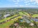 Aerial view showcasing a golf course, tennis courts, pool, and community amenities amidst a lush, green landscape at 1094 Red Maple Way, New Smyrna Beach, FL 32168