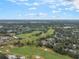 Scenic aerial of a golf course community with lush greenery under blue skies and scattered clouds at 1094 Red Maple Way, New Smyrna Beach, FL 32168