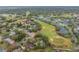 Aerial view of a neighborhood nestled along a lush green golf course with mature trees and serene landscaping at 1094 Red Maple Way, New Smyrna Beach, FL 32168