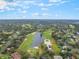 Expansive aerial view of a golf course community with lakes and lush greenery under a bright, cloudy sky at 1094 Red Maple Way, New Smyrna Beach, FL 32168