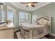 Charming bedroom featuring a decorative wooden bed frame and two windows at 1094 Red Maple Way, New Smyrna Beach, FL 32168