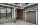 Welcoming entrance featuring stone accents, a covered porch, and an attached one-car garage at 1094 Red Maple Way, New Smyrna Beach, FL 32168