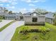 Landscaped front yard features palm trees and greenery, enhancing the curb appeal of this lovely home at 1094 Red Maple Way, New Smyrna Beach, FL 32168