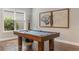 Close up of pool table, hardwood floors, and modern art in the game room at 1094 Red Maple Way, New Smyrna Beach, FL 32168