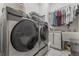 Laundry room featuring a washer and dryer with a hanging rack, and a utility sink at 1094 Red Maple Way, New Smyrna Beach, FL 32168