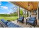 Relaxing covered patio featuring outdoor seating, a ceiling fan and views of the lush backyard at 1094 Red Maple Way, New Smyrna Beach, FL 32168