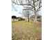 Wide view of backyard with mature trees, partial fencing, storage shed, and ample lawn space at 1197 Village Forest Pl, Winter Park, FL 32792