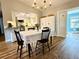 Inviting dining area featuring hardwood floors, a stylish chandelier, and an open layout to the adjacent kitchen at 1197 Village Forest Pl, Winter Park, FL 32792