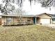 Charming single-story home with a well-maintained lawn, bright blue front door, and attached two car garage at 1197 Village Forest Pl, Winter Park, FL 32792