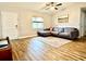 Bright living room featuring hardwood floors, a comfortable gray sofa, and a large window with natural light at 1197 Village Forest Pl, Winter Park, FL 32792