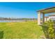 Lush backyard featuring a pond view, complemented by a covered porch and tasteful landscaping at 125 Links Terrace Blvd, Daytona Beach, FL 32124