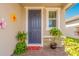 Blue front door with plants on a brick-paved front porch, creating a welcoming entrance at 125 Links Terrace Blvd, Daytona Beach, FL 32124