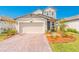 Charming single-Gathering home with a brick driveway, a two-car garage and inviting landscaping at 125 Links Terrace Blvd, Daytona Beach, FL 32124