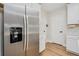 Stainless steel refrigerator stands out against white cabinets and wood-look flooring in kitchen at 125 Links Terrace Blvd, Daytona Beach, FL 32124