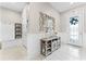 Bright foyer with tiled floors, decorative mirror, stylish console table, and a view of the elegant front door at 1298 Patterson Ter, Lake Mary, FL 32746