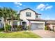 Beautiful two-story home with a well-manicured lawn, brick driveway, and a welcoming facade with an American flag at 1298 Patterson Ter, Lake Mary, FL 32746