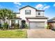 Charming two-story home showcasing a landscaped yard, brick driveway, and a welcoming two-car garage at 1298 Patterson Ter, Lake Mary, FL 32746