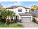 Inviting two-story home featuring solar panels, lush landscaping, and a charming brick driveway leading to a garage at 1298 Patterson Ter, Lake Mary, FL 32746