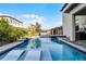 Stunning pool area with in-pool lounge chairs, a waterfall feature, and lush tropical landscaping at 1298 Patterson Ter, Lake Mary, FL 32746