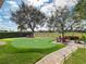 Backyard features a putting green, a brick-paver seating area, and mature trees at 13106 Alderley Dr, Orlando, FL 32832