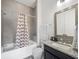 Bathroom featuring a shower-tub combo with a chevron curtain, gray tile, and a vanity with granite countertop at 13106 Alderley Dr, Orlando, FL 32832