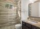 Well-lit bathroom featuring a glass-enclosed shower with gray tile, granite countertops, and a dark vanity at 13106 Alderley Dr, Orlando, FL 32832