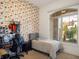 Bright bedroom with quirky wallpaper and a large window overlooking the landscaped backyard at 13106 Alderley Dr, Orlando, FL 32832