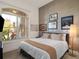 Cozy bedroom featuring a queen-size bed, wood-look accent wall and a window that brings in natural light at 13106 Alderley Dr, Orlando, FL 32832