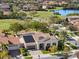 Aerial view of a property with a home with solar panels on a golf course near a lake at 13106 Alderley Dr, Orlando, FL 32832