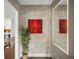 Modern hallway with gray wallpaper, red art, plant, and mirror with accent lighting at 13106 Alderley Dr, Orlando, FL 32832