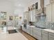 Modern kitchen with stainless steel appliances, gray cabinetry, mosaic backsplash, and a view to the outside at 13106 Alderley Dr, Orlando, FL 32832