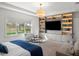 Bright main bedroom featuring a large window and a custom built-in shelving unit with a television at 13106 Alderley Dr, Orlando, FL 32832