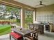 Covered outdoor kitchen with bar seating, tile backsplash, and view of putting green at 13106 Alderley Dr, Orlando, FL 32832