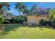 Backyard featuring a manicured lawn, decorative water fountain, and mature trees at 1400 Alabama Dr, Winter Park, FL 32789