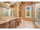 An elegant bathroom featuring double vanities, a glass enclosed shower and a large soaking tub at 1400 Alabama Dr, Winter Park, FL 32789