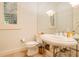 Elegant bathroom featuring a pedestal sink, a large mirror, and a window with natural light for a serene experience at 1400 Alabama Dr, Winter Park, FL 32789