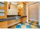 Stylish bathroom featuring a dark stone countertop, patterned floor, vanity lighting and wood cabinets at 1400 Alabama Dr, Winter Park, FL 32789