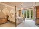 Spacious bedroom showcasing a four-poster bed, decorative walls and french door access to the exterior at 1400 Alabama Dr, Winter Park, FL 32789