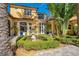 Elegant yellow stucco exterior with lush landscaping, fountain, and a mix of modern and classic architectural elements at 1400 Alabama Dr, Winter Park, FL 32789