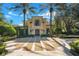 Stunning Mediterranean home featuring a circular driveway and meticulously landscaped grounds with mature palm trees at 1400 Alabama Dr, Winter Park, FL 32789