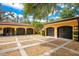 Spacious three-car garage with stylish black carriage doors and expansive shell driveway at 1400 Alabama Dr, Winter Park, FL 32789