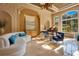 Elegant living room showcasing a curved sofa, grand piano, and sun-drenched windows with lush backyard views at 1400 Alabama Dr, Winter Park, FL 32789