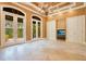 Spacious living room with beautiful tile flooring, a coffered ceiling, and large doors opening to the outside at 1400 Alabama Dr, Winter Park, FL 32789